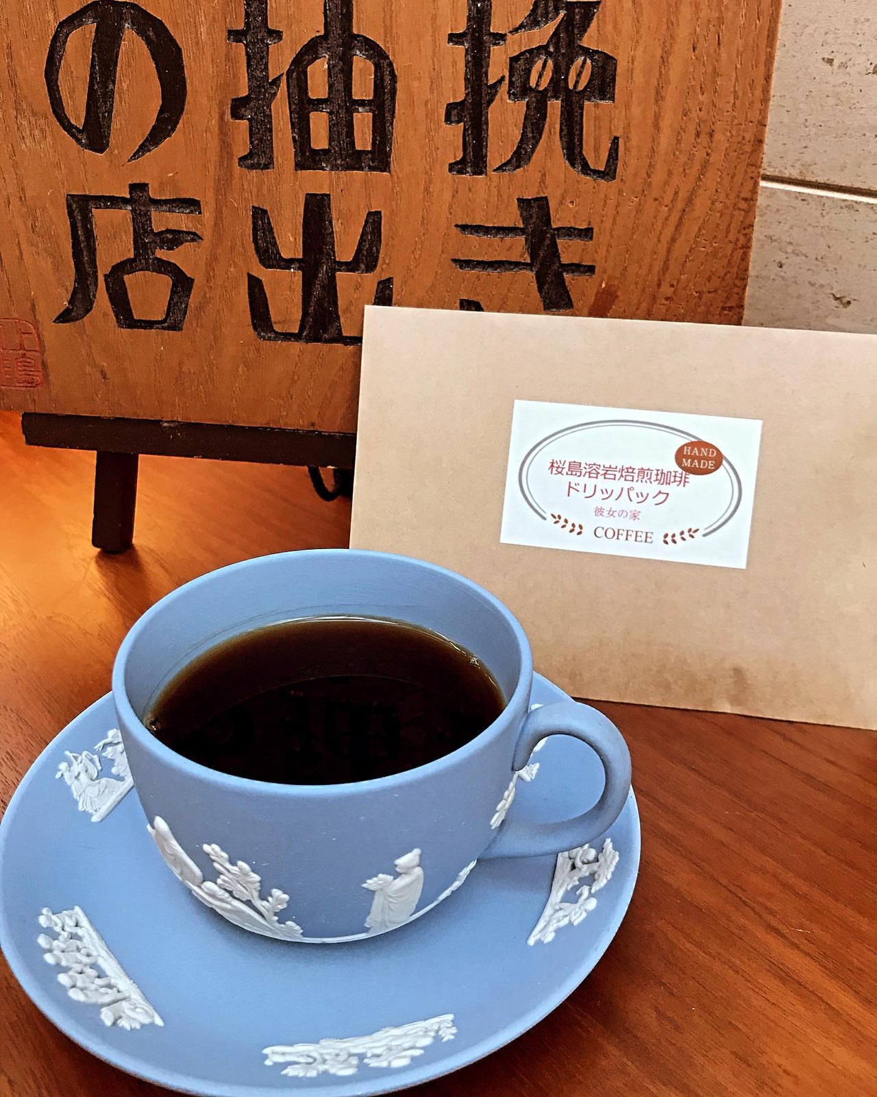 一杯挽き抽出の店の看板と淹れたての珈琲
